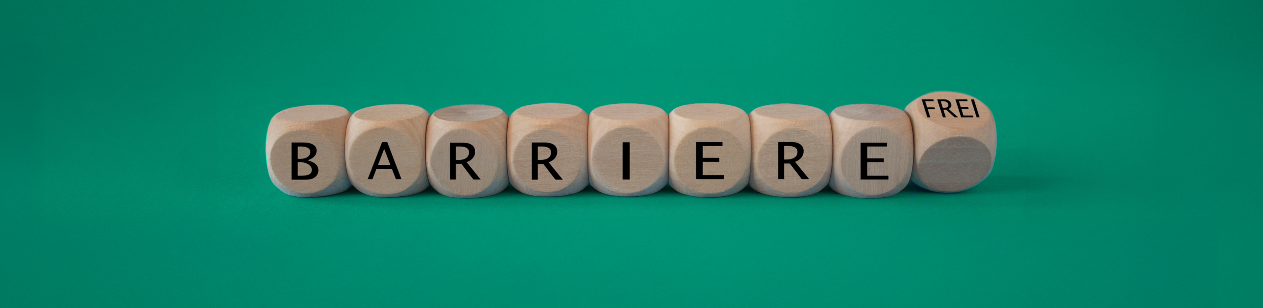 Würfel die in einer Linie angeordnet sind und auf jedem steht ein einzelner Buchstabe die das Wort Barriere ergeben. Der letzte Würfel befindet sich im Fall und dort steht "frei" drauf.